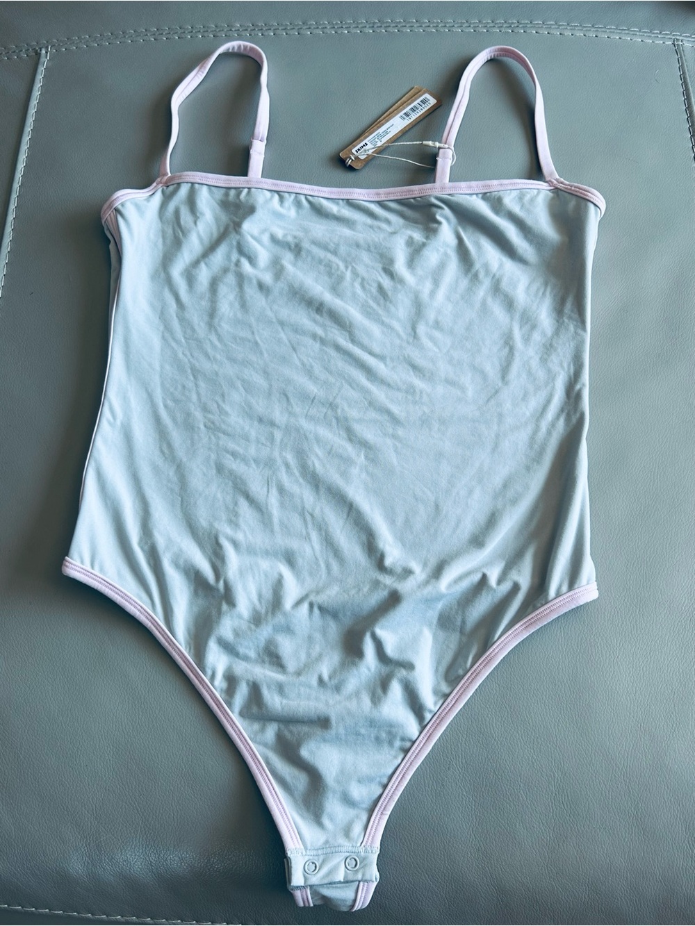 Skims light grey and pink bodysuit